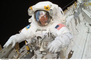 Col. Michael Fossum in an astronaut suit floating in space.